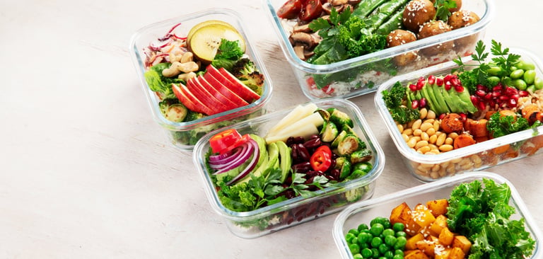 Preparing healthy meals with fresh ingredients in containers on a light background