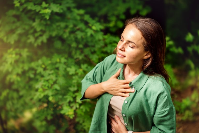 Young adult woman practising breathing exercise in the forest in summer