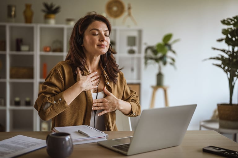 Woman focusing on mental well-being and stress relief, practicing mindfulness and deep breathing with hands on her chest